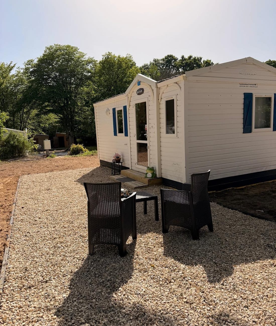 Mobil-home et sa terrasse au calme, entourés d'arbres, au camping Les Cabanes de Condé